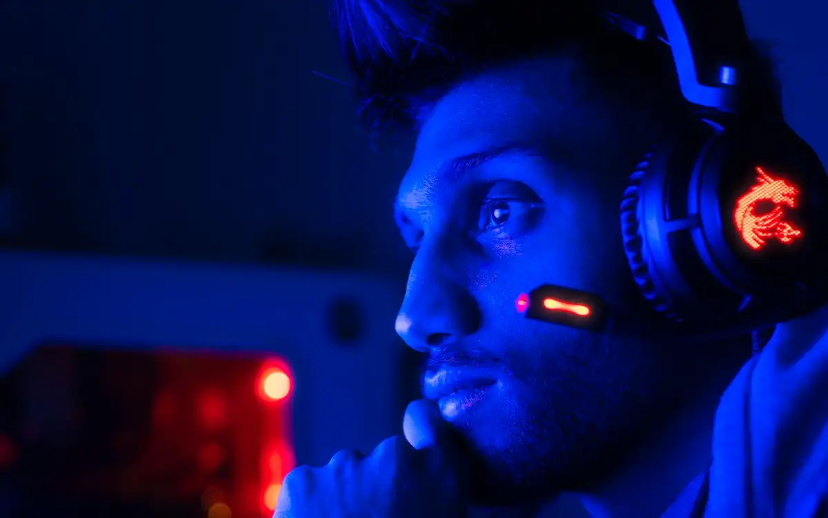 Gamer wearing a glowing headset in blue light – PHFUN slots and arcade night
